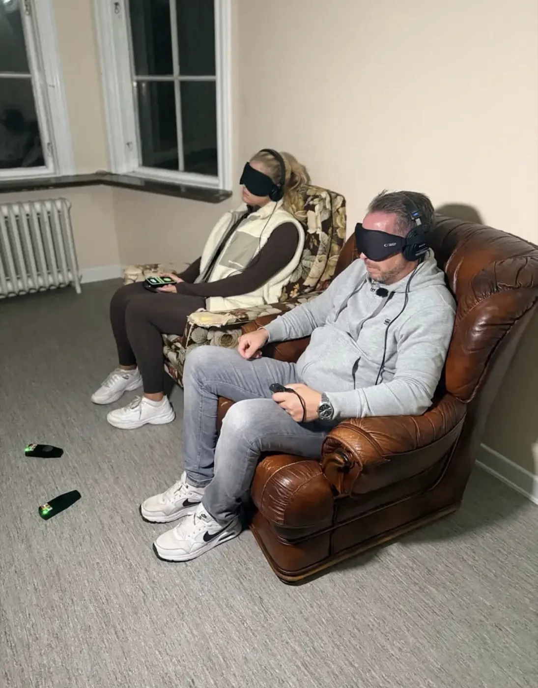 To fra teamet sitter med bind for øynene og hodetelefoner under en sesjon, med målere på gulvet foran seg.