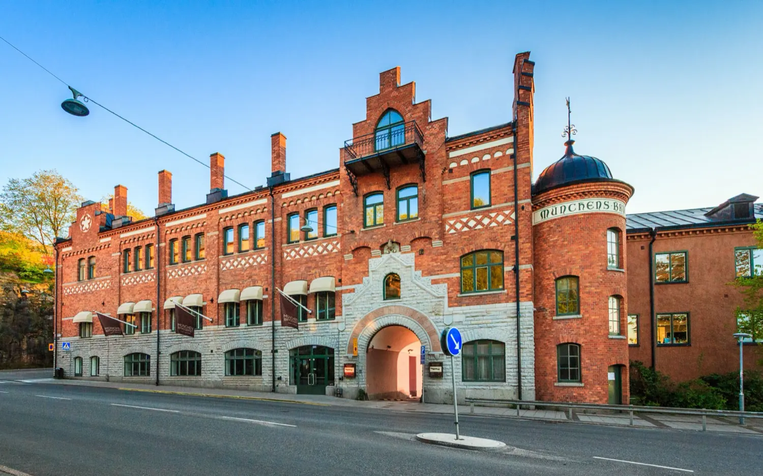 The brick facade of Münchenbryggeriet in evening light, its name set into the brickwork