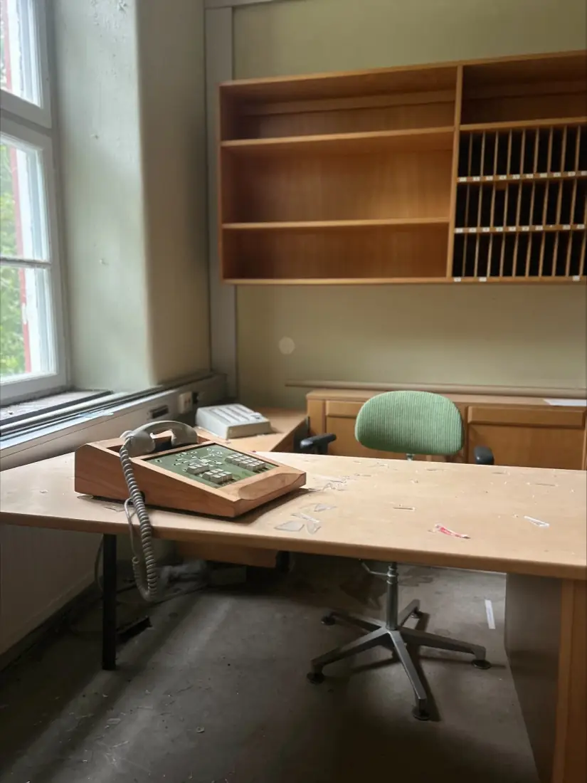 An office with an old telephone switchboard and empty shelving at the sanatorium